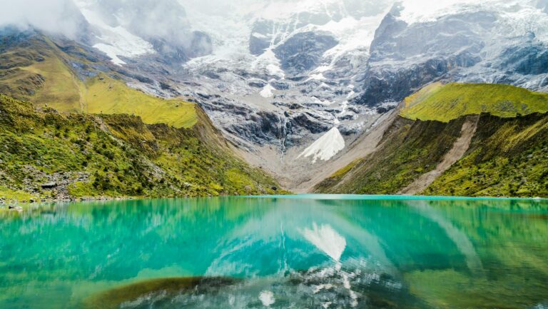 Turquoise glacial Humantay Lake surrounded by snow-capped Andean peaks (humantay lake) | Viajes Peru Tour