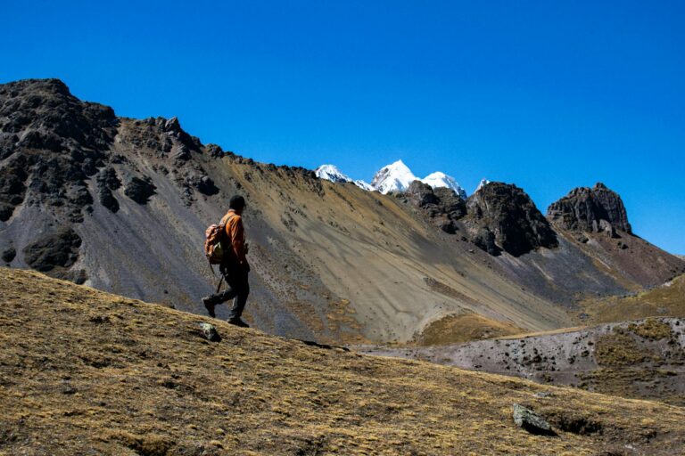 Hiker exploring the rugged Andes mountains under a clear blue sky near Cusco, Peru (salkantay trek) | Viajes Peru Tour