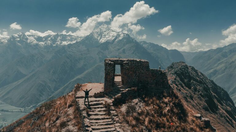 Hiker at Inca ruins with Andes mountains (short inca trail tour) | Viajes Peru Tour